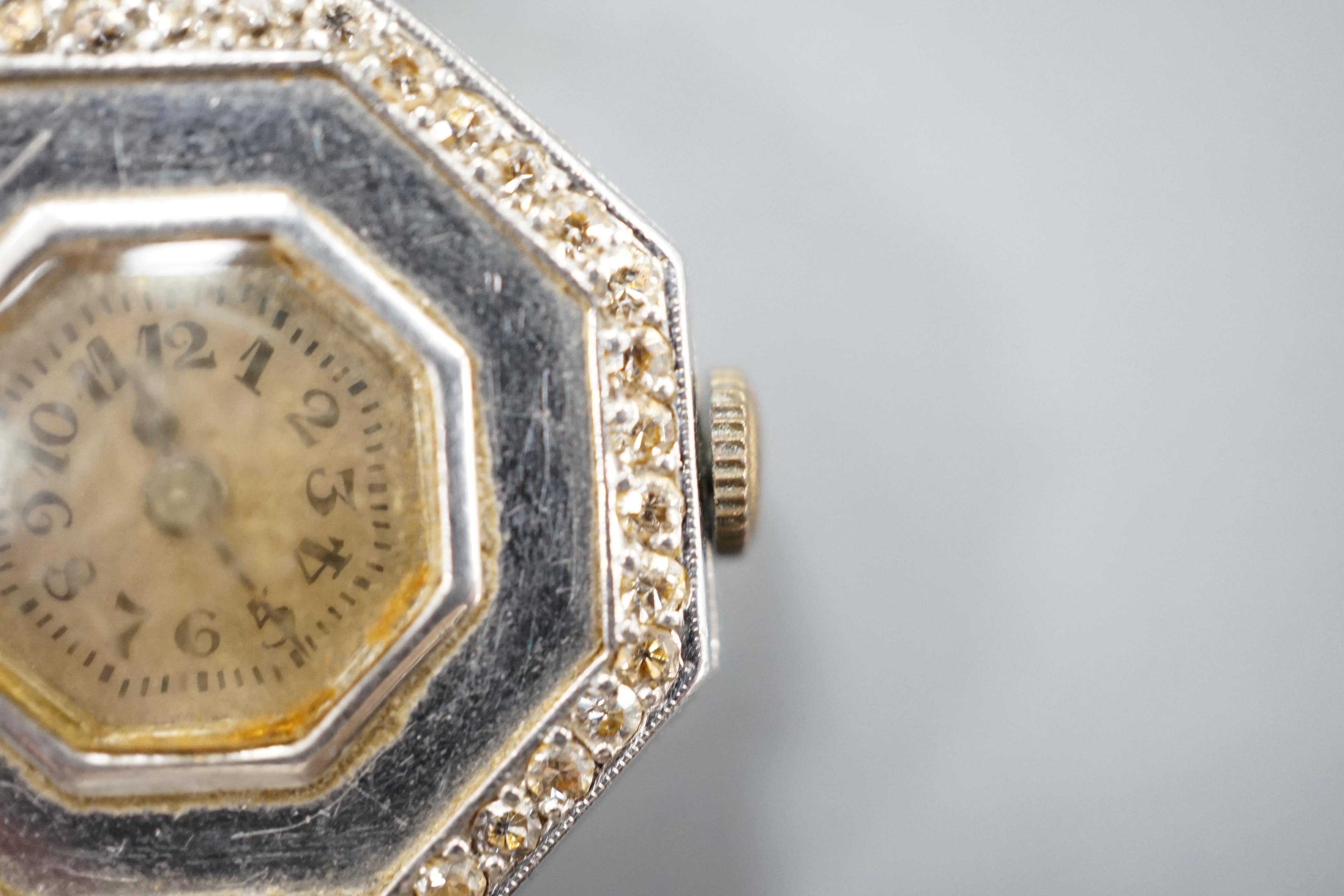 A lady's early 20th century white metal and diamond chip set manual wind octagonal cocktail watch, on a white metal twin strand mesh bracelet, gross 27.4 grams.